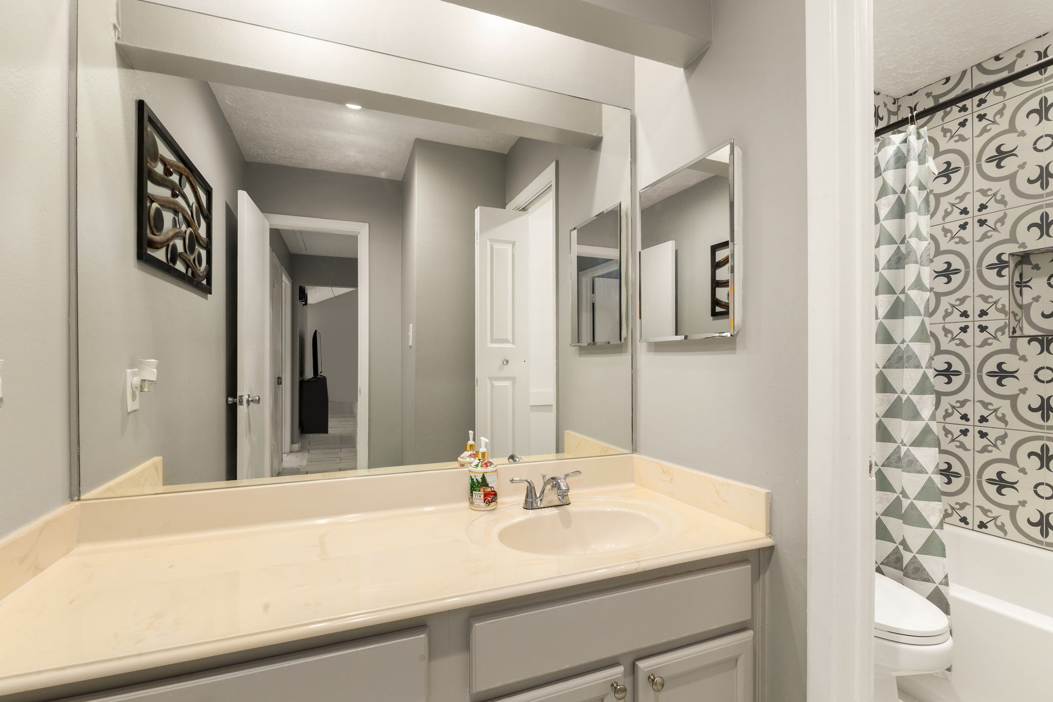 14110 Eventide Drive Cypress, TX 77429 - Photo 21 of 27 Modern bathroom with a sleek vanity, large mirror, and patterned tile shower. Neutral tones create a clean, contemporary feel.
