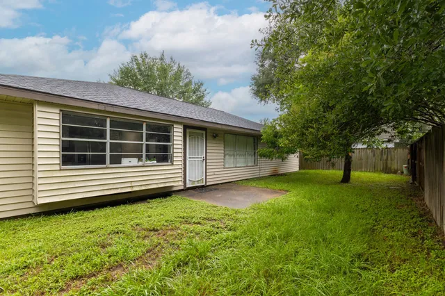a front view of a house with a garden and trees