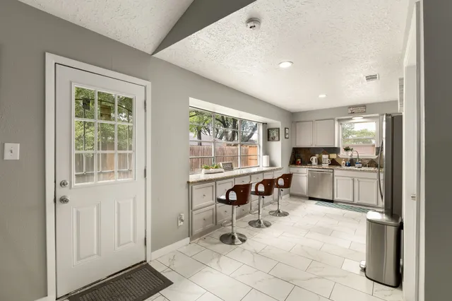 a kitchen with a sink and chairs