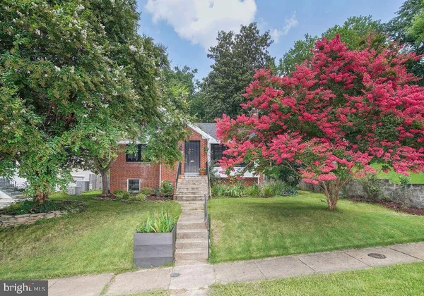 a front view of a house with a yard and fountain