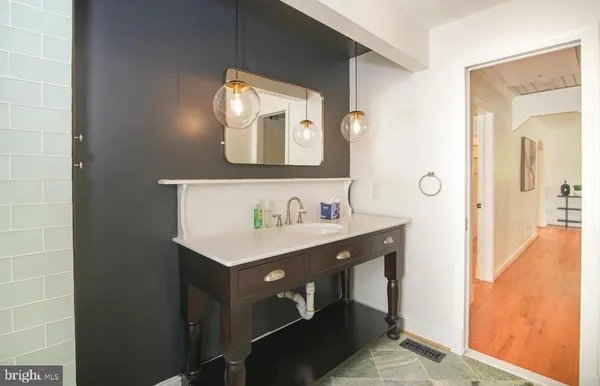 a bathroom with a sink vanity and a mirror