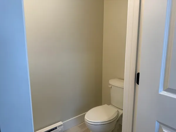 a white toilet sitting next to a shower