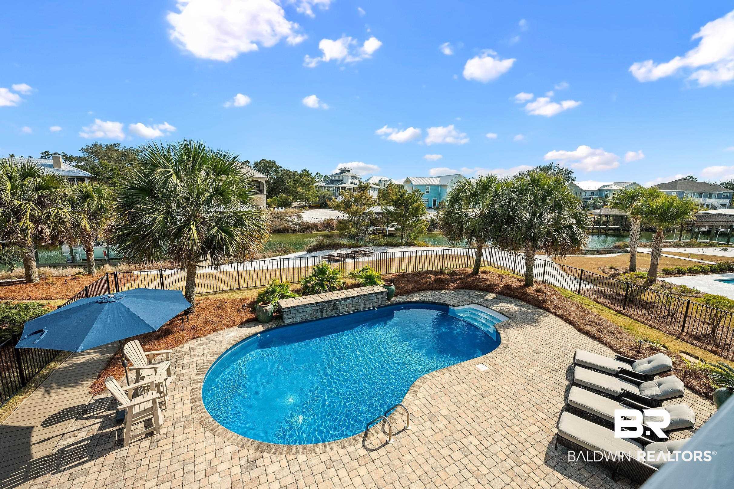 33186 Marlin Key Drive Orange Beach, AL 36561 - Photo 31 of 87 View of pool with patio surround, a fenced backyard, a water view, and a residential view