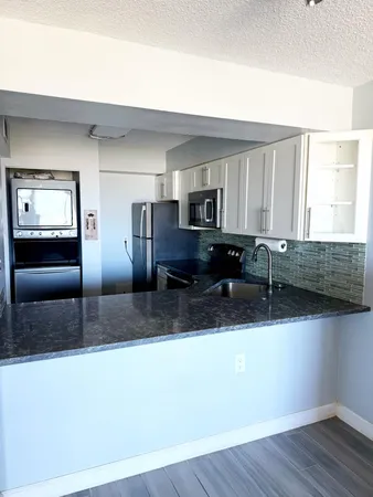 a kitchen with stainless steel appliances granite countertop a sink a stove and a microwave