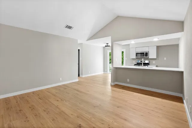 a view of a kitchen with wooden floor and a sink
