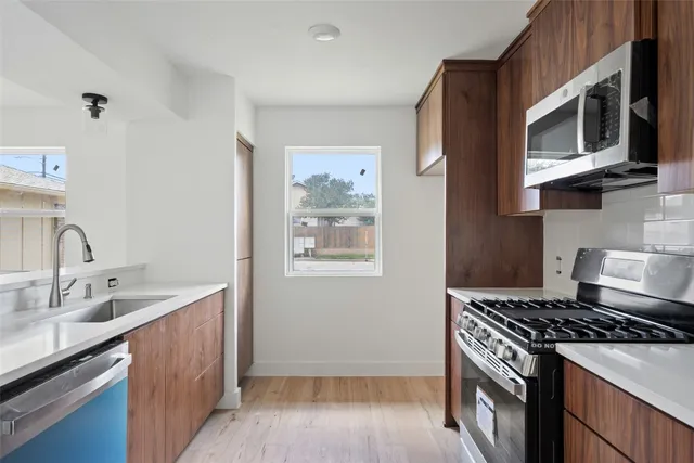a kitchen with stainless steel appliances a stove a microwave a sink and cabinets