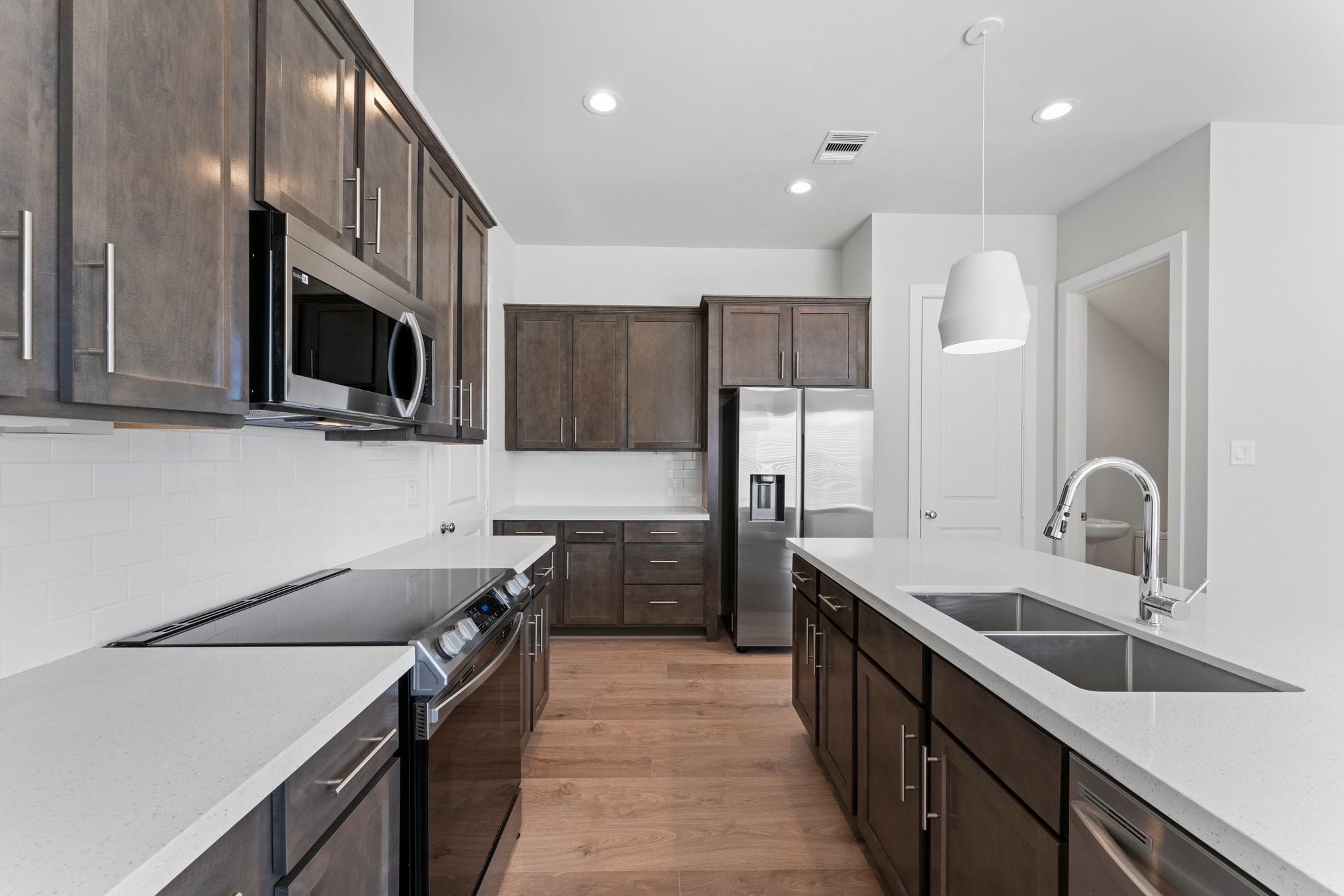 5904 Jasper Jones Way Houston, TX 77091 - Photo 9 of 37 a kitchen with stainless steel appliances a sink dishwasher a stove top oven a refrigerator with wooden cabinets and floor