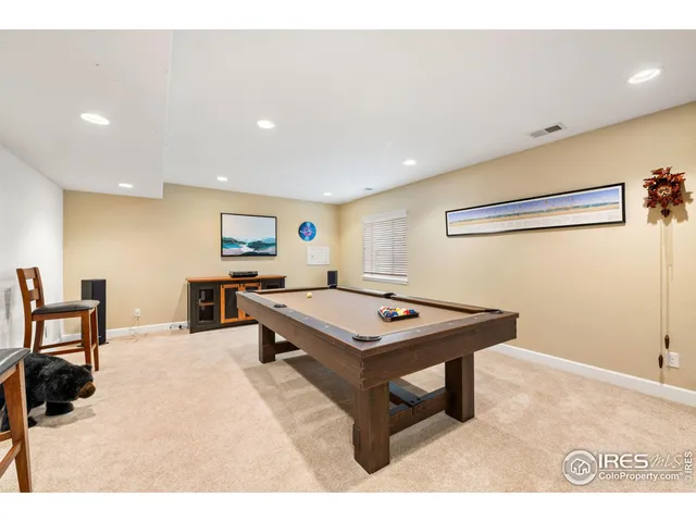 a room with furniture pool table and a window