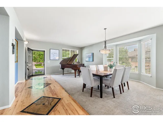 a dining room with furniture a chandelier and wooden floor