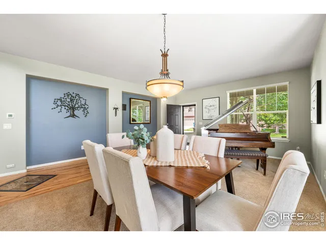 a dining room with furniture a chandelier and window