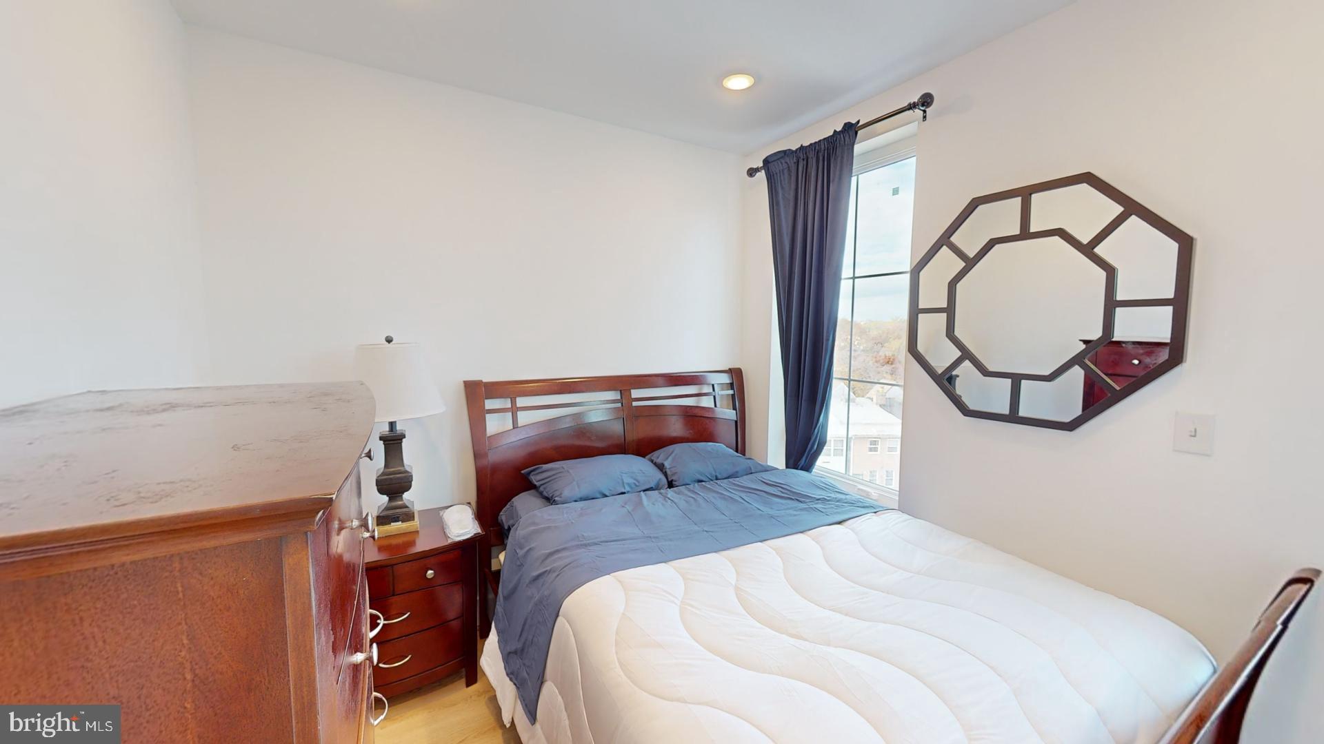 201 Kennedy Street Northwest, Unit 8 Washington, DC 20011 - Photo 6 of 14 a bedroom with a bed and a large mirror on the dresser