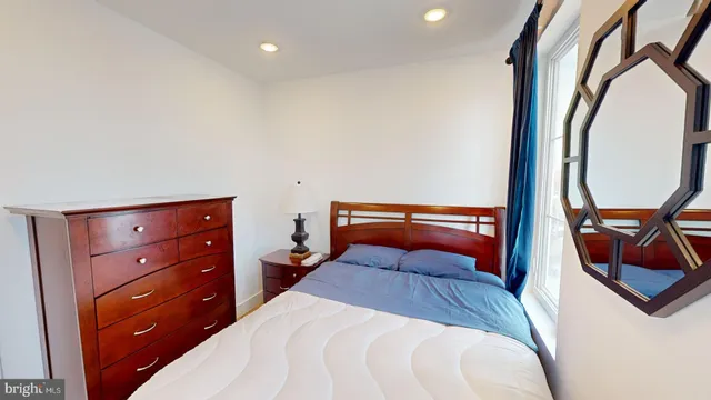 a bedroom with a bed and a painting on the wall