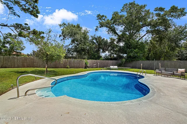 a view of a swimming pool with a chairs in the patio
