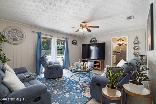 a living room with furniture a large window and a flat screen tv