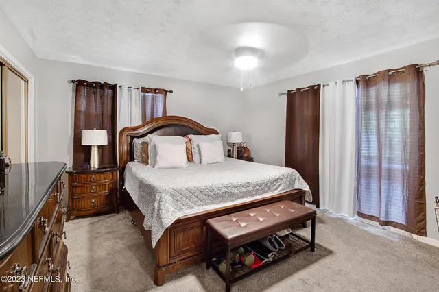 a bedroom with a bed a closet and flat screen tv