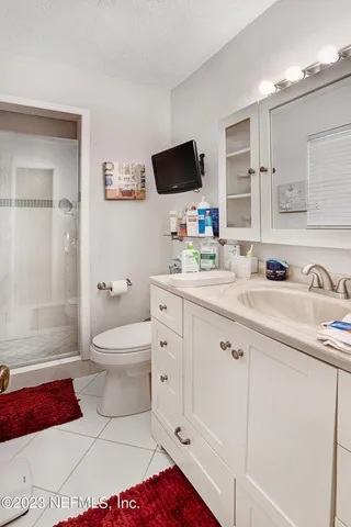 a spacious bathroom with a toilet a sink and a mirror