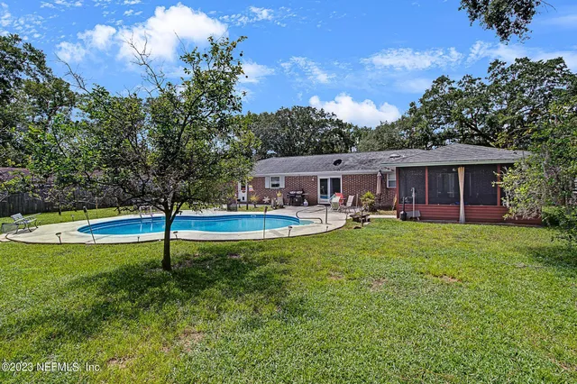a view of a house with a swimming pool and a yard