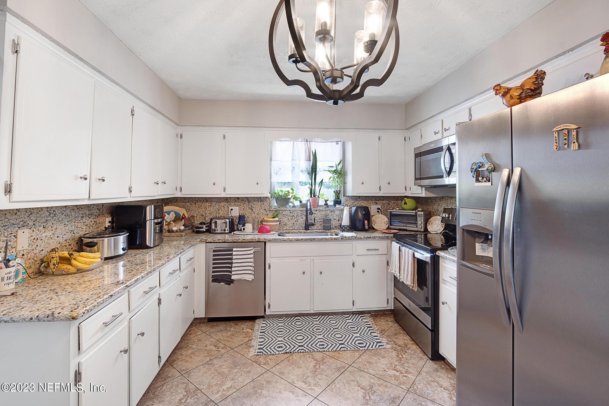 2411 Aquarius Road Orange Park, FL 32073 - Photo 10 of 24 a kitchen with a sink window and cabinets
