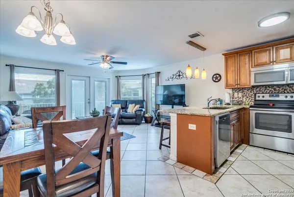 a kitchen with a stove a table and chairs in it