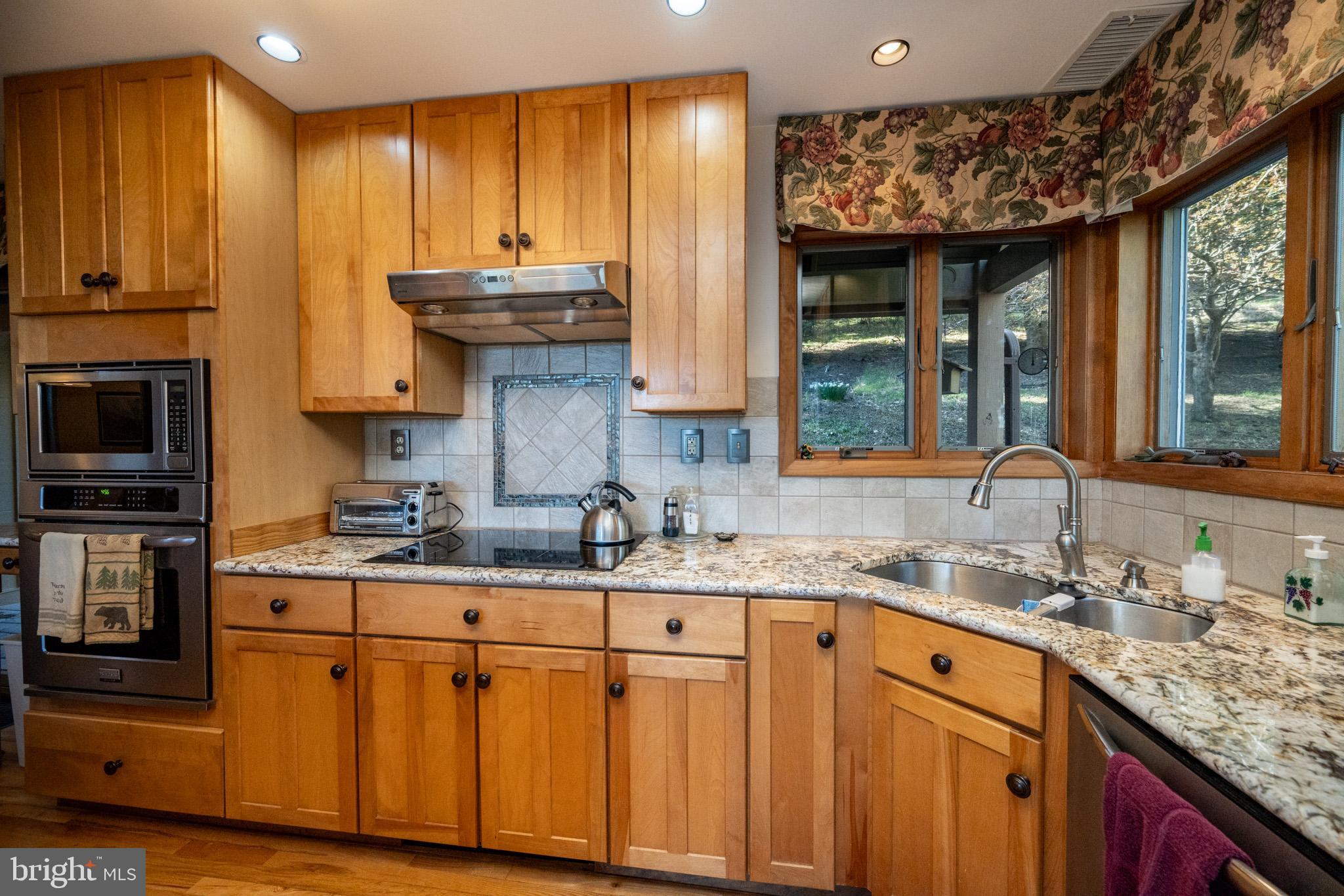 59 Glenview Road Swanton, MD 21561 - Photo 17 of 85 a kitchen with stainless steel appliances granite countertop a sink stove and cabinets