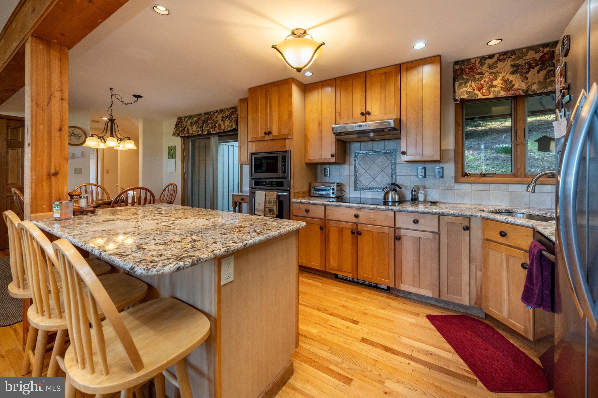 59 Glenview Road Swanton, MD 21561 - Photo 18 of 85 a kitchen with stainless steel appliances granite countertop a sink a stove and a wooden cabinets