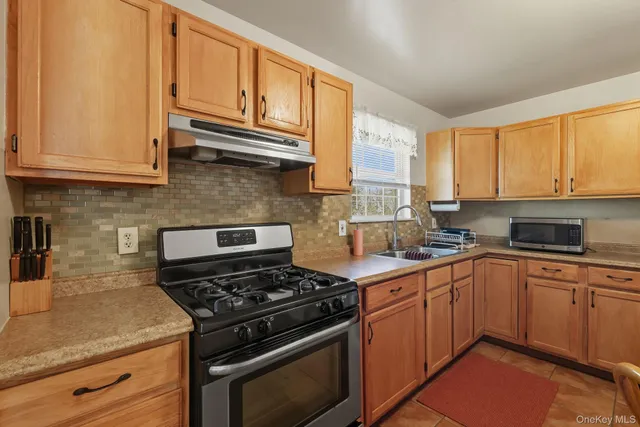 a kitchen with stainless steel appliances granite countertop a stove a sink and a microwave