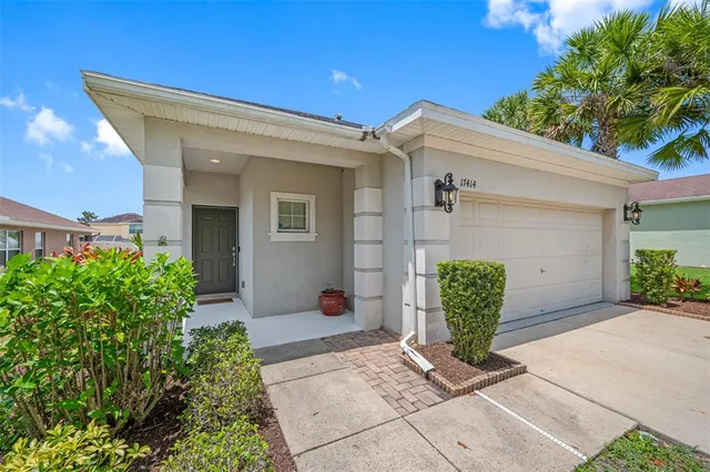 a view of a house with potted plants and a bench