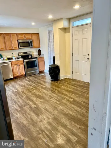 a kitchen with stainless steel appliances kitchen island granite countertop a refrigerator and microwave