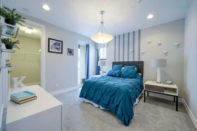 a spacious bedroom with a bed and a chandelier