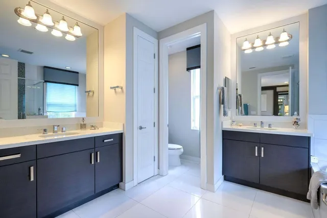 a spacious bathroom with a double vanity sink mirror and toilet