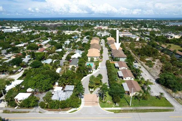 an aerial view of residential houses with outdoor space and trees