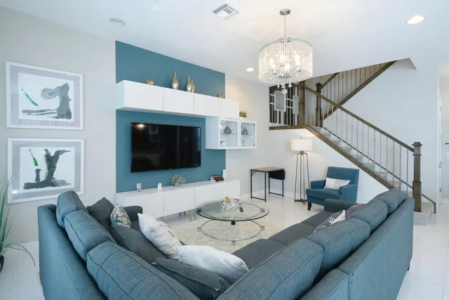 a living room with furniture a chandelier and a fireplace