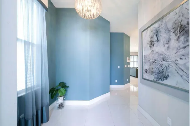 a view of a hallway with wooden floor and a chandelier