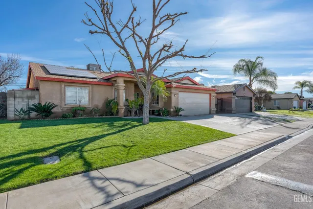 a front view of a house with a yard and potted plants