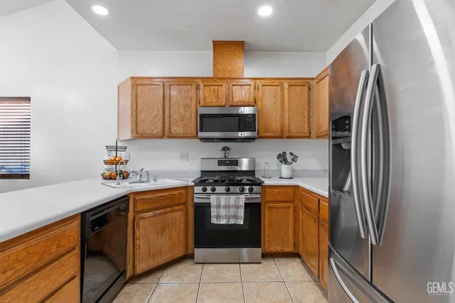 a kitchen with stainless steel appliances a stove a sink and a refrigerator
