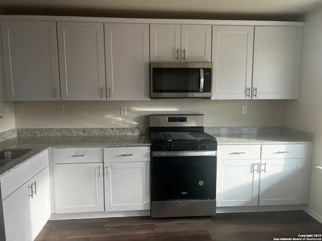 a kitchen with white cabinets and black appliances