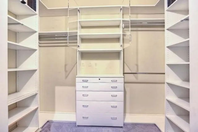 a view of walk in closet with empty racks