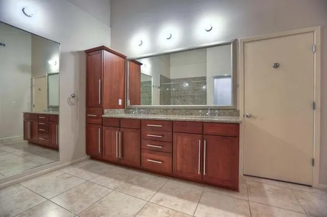 a bathroom with a granite countertop sink and a mirror