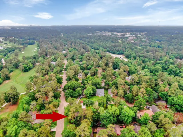 an aerial view of residential houses with outdoor space and trees