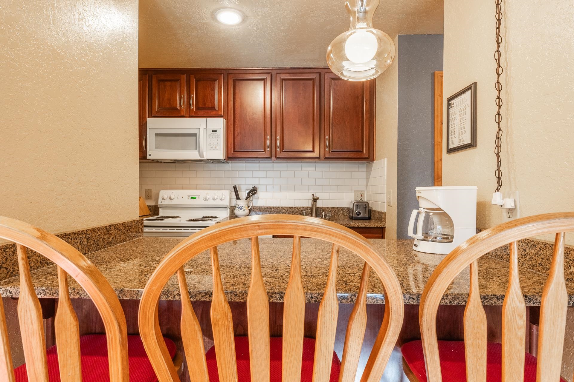 153 Lake Mary Road, Unit 29 Mammoth Lakes, CA 93546 - Photo 10 of 44 a very nice looking kitchen with granite countertop a stove a sink dishwasher and cabinets with wooden floor