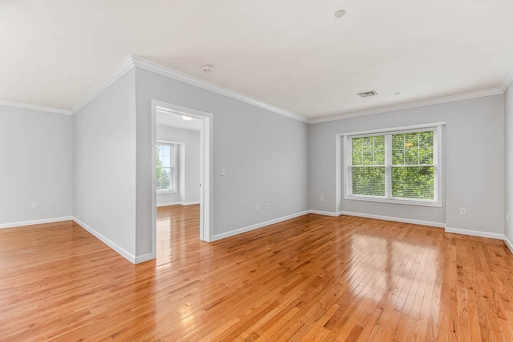 446 Belgrade Avenue, Unit 208 Boston, MA 02132 - Photo 14 of 36 a view of an empty room with wooden floor and a window