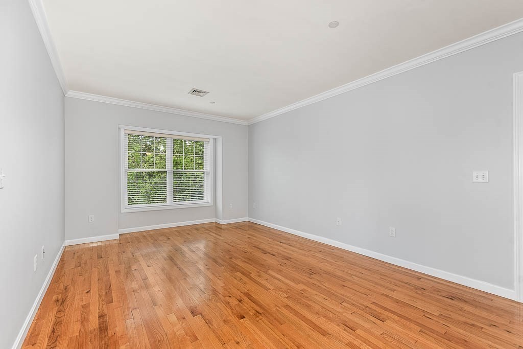 446 Belgrade Avenue, Unit 208 Boston, MA 02132 - Photo 15 of 36 a view of an empty room with wooden floor and a window