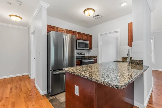 a kitchen with stainless steel appliances granite countertop a sink stove and refrigerator