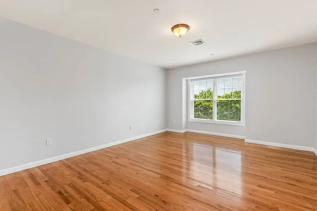 a view of an empty room with wooden floor