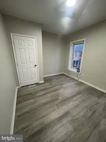 an empty room with wooden floor and closet