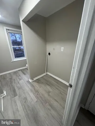 an empty room with wooden floor and window