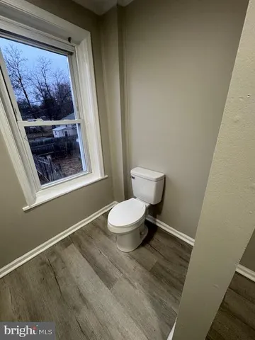 a bathroom with a toilet and a painting on the wall