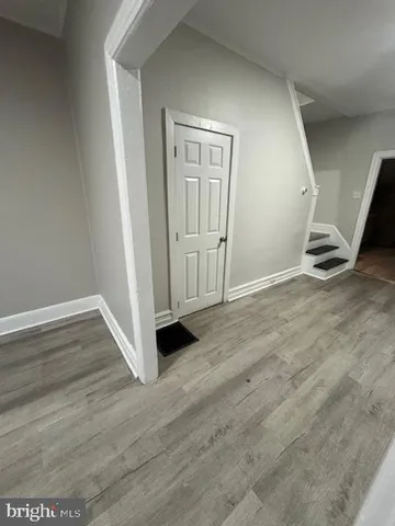 an empty room with wooden floor and white walls