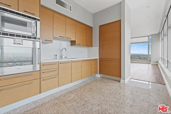 a kitchen with granite countertop a refrigerator and cabinets