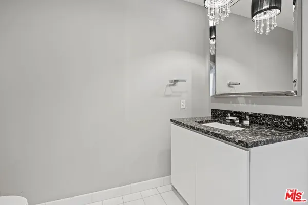 a bathroom with a granite countertop sink and cabinets
